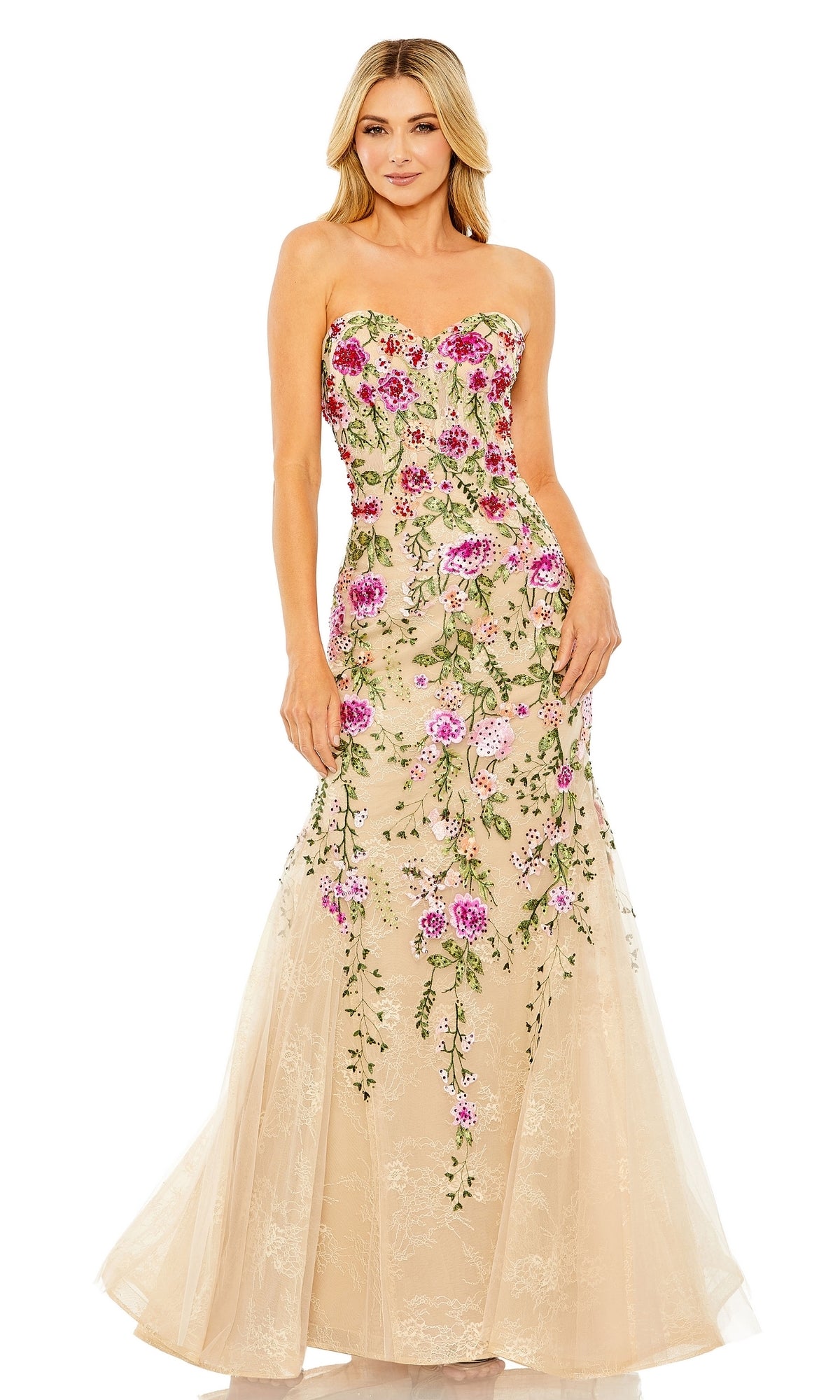 A woman stands smiling with her hands at her sides, wearing the Mac Duggal 20652 strapless long formal dress featuring a sweetheart neckline and pink floral embroidery.